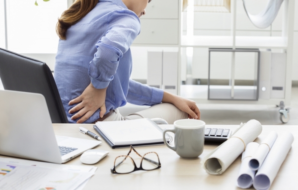 Mulher que trabalha sentada com dor na costas: possibilidade de hérnia de disco